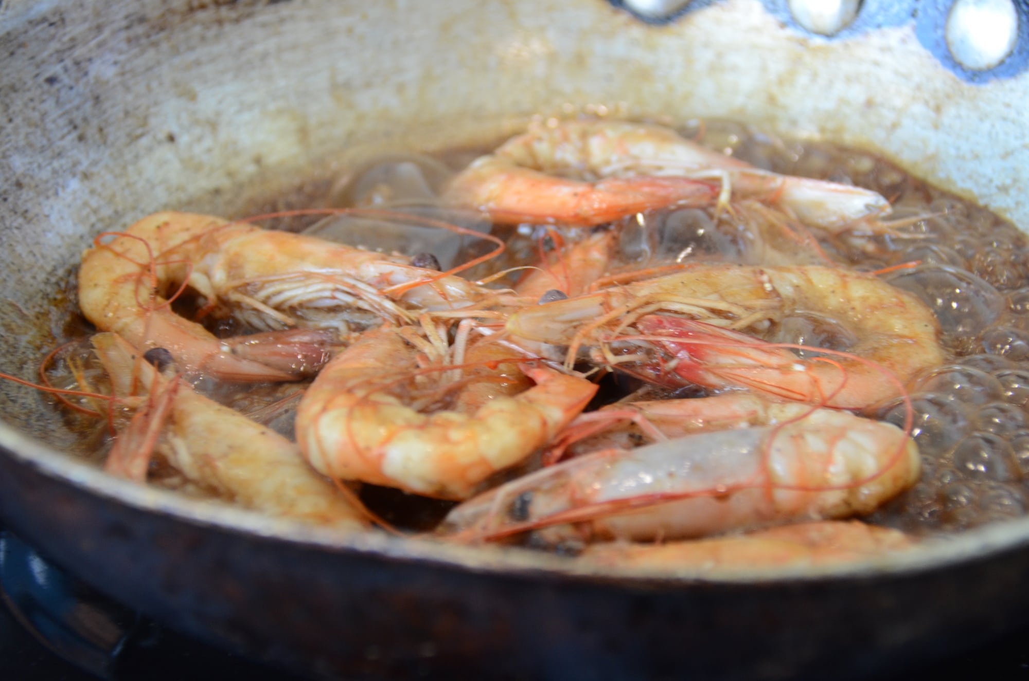 Image of shrimp being cooked in a sauce in a pan