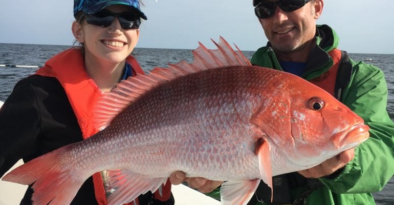 large red snapper being held by La Sea Grant and LDWF employees