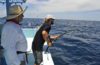 charter boat deckhand gets fish on line for customer